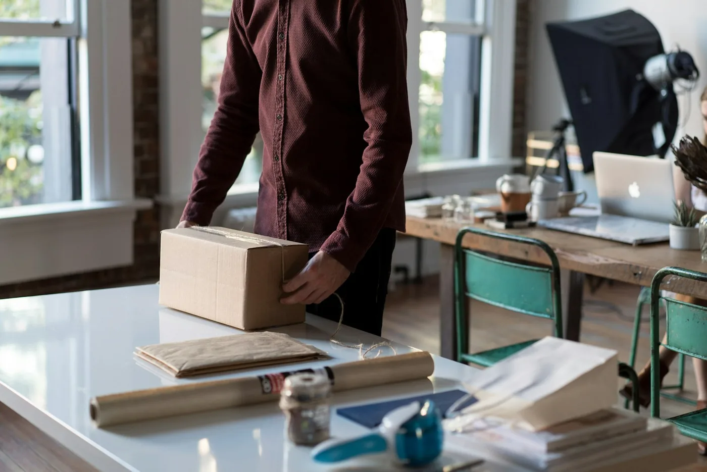 A cardboard box being packed at a desk