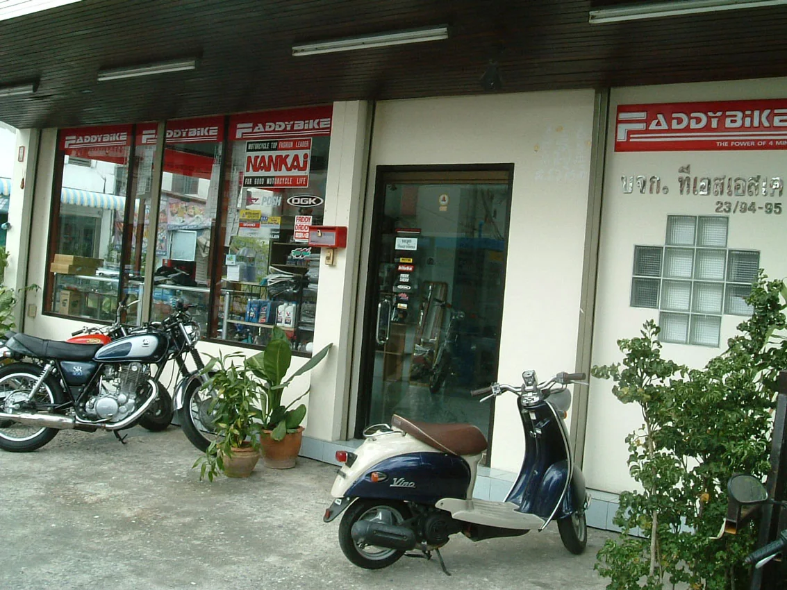 The Faddybike shopfront in Ladprao, Bangkok, with Nankai and Faddybike signage above the windows and motorcycles parked outside.