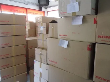 Stacked cartons of Honda genuine parts inside the Faddybike shop.