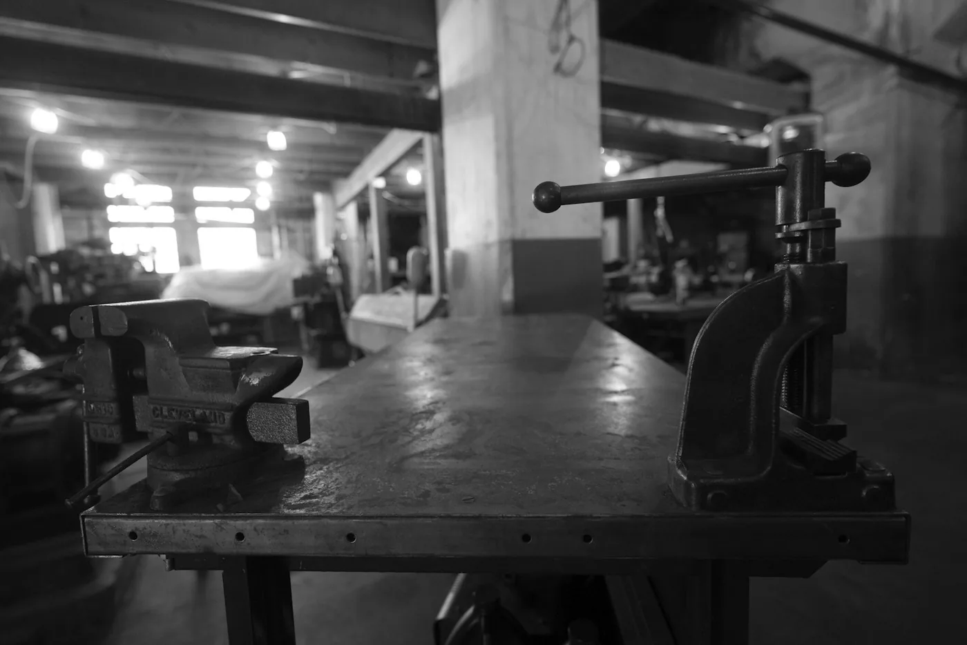 A metal component being photographed on a workbench