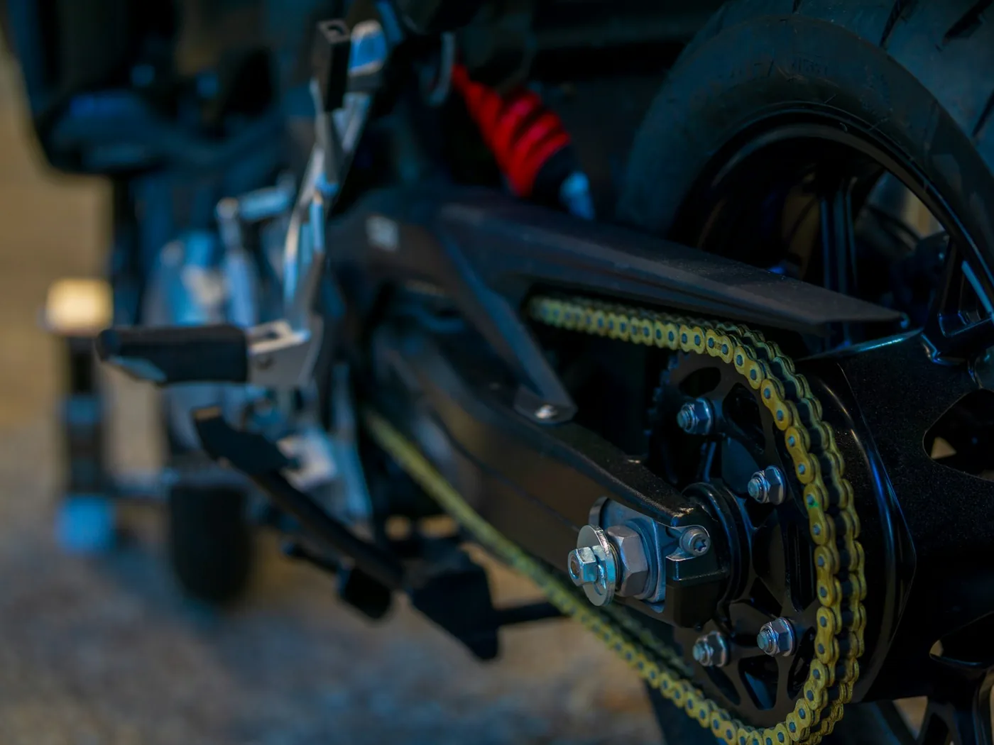 A motorcycle rear sprocket and drive chain seen close up