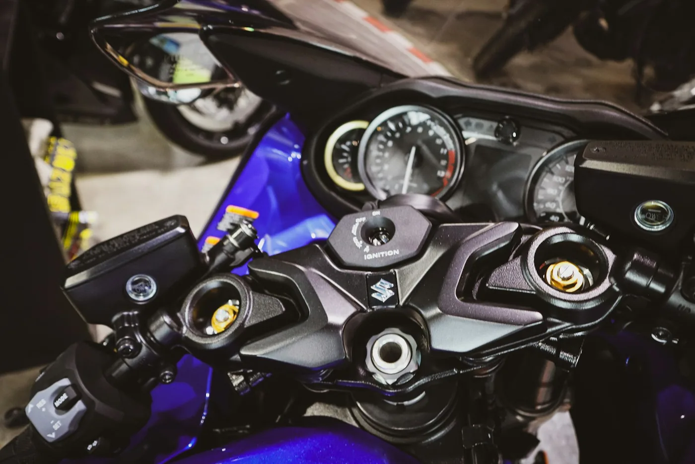 Close-up of a blue motorcycle's handlebars and dashboard