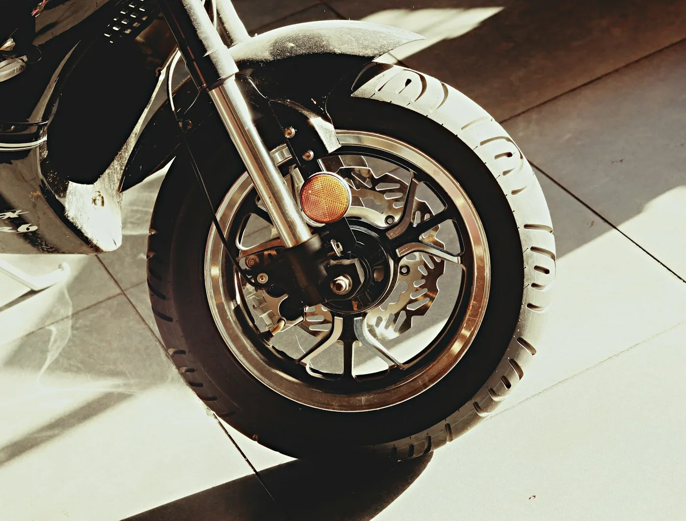 The front forks and wheel of a small motorcycle