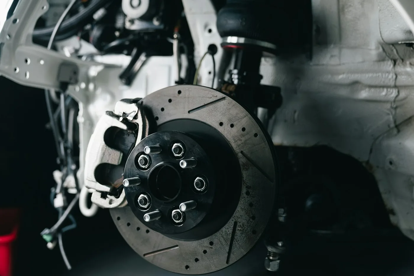 A drilled and slotted brake disc with its caliper