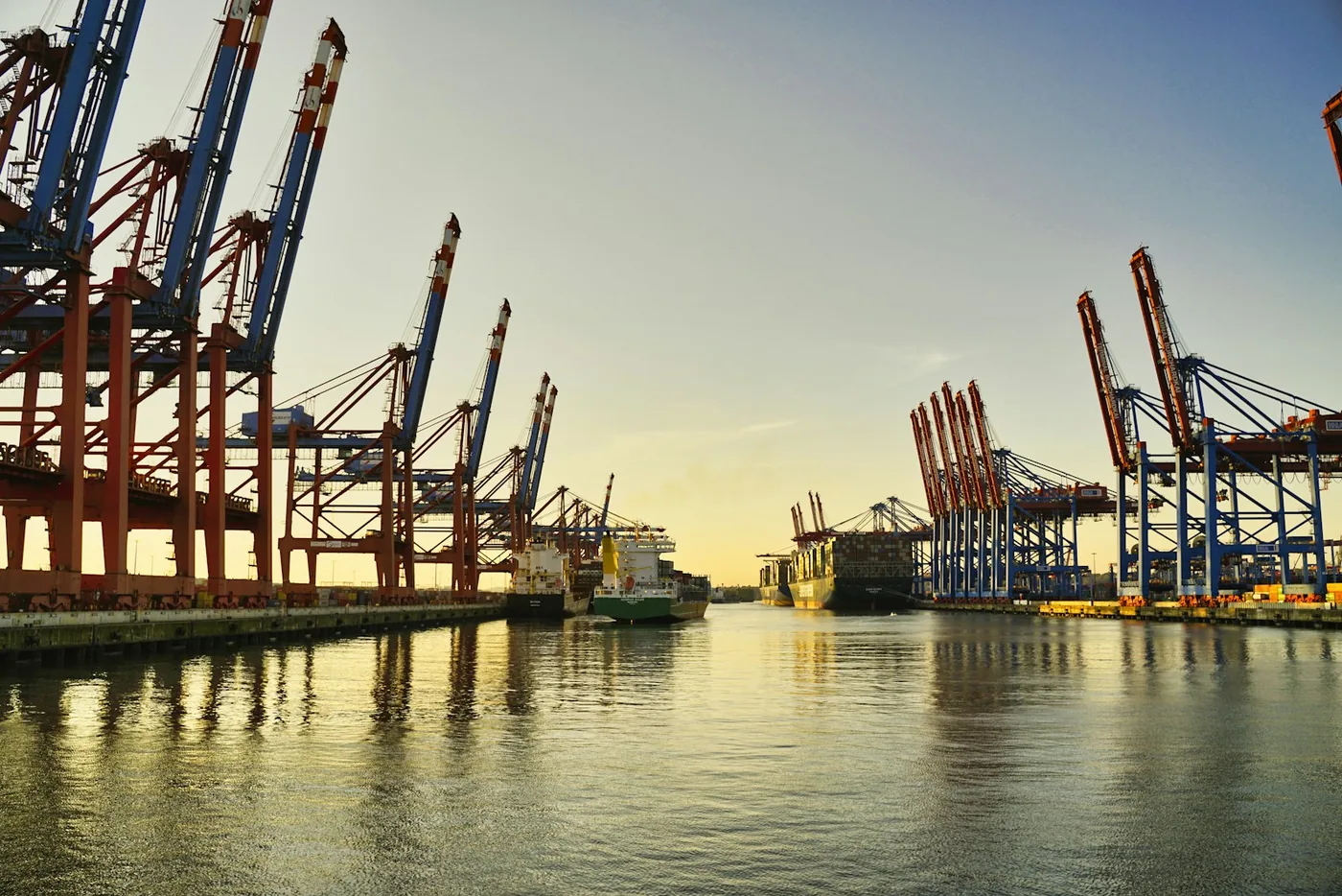 A harbour at dusk with its cranes lit