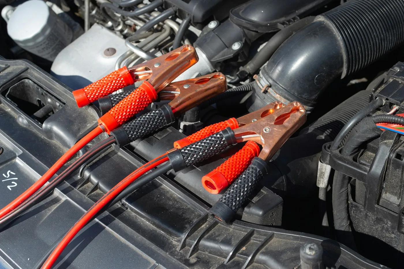 Jump leads clamped to a battery