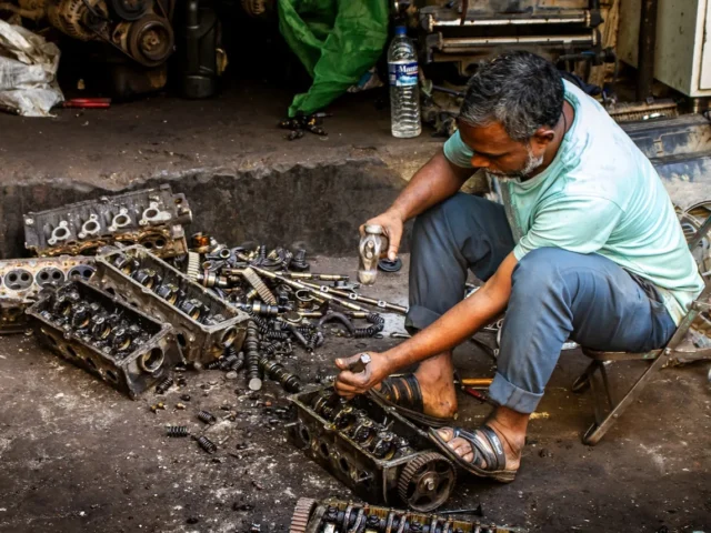 A mechanic working on engine parts in a workshop
