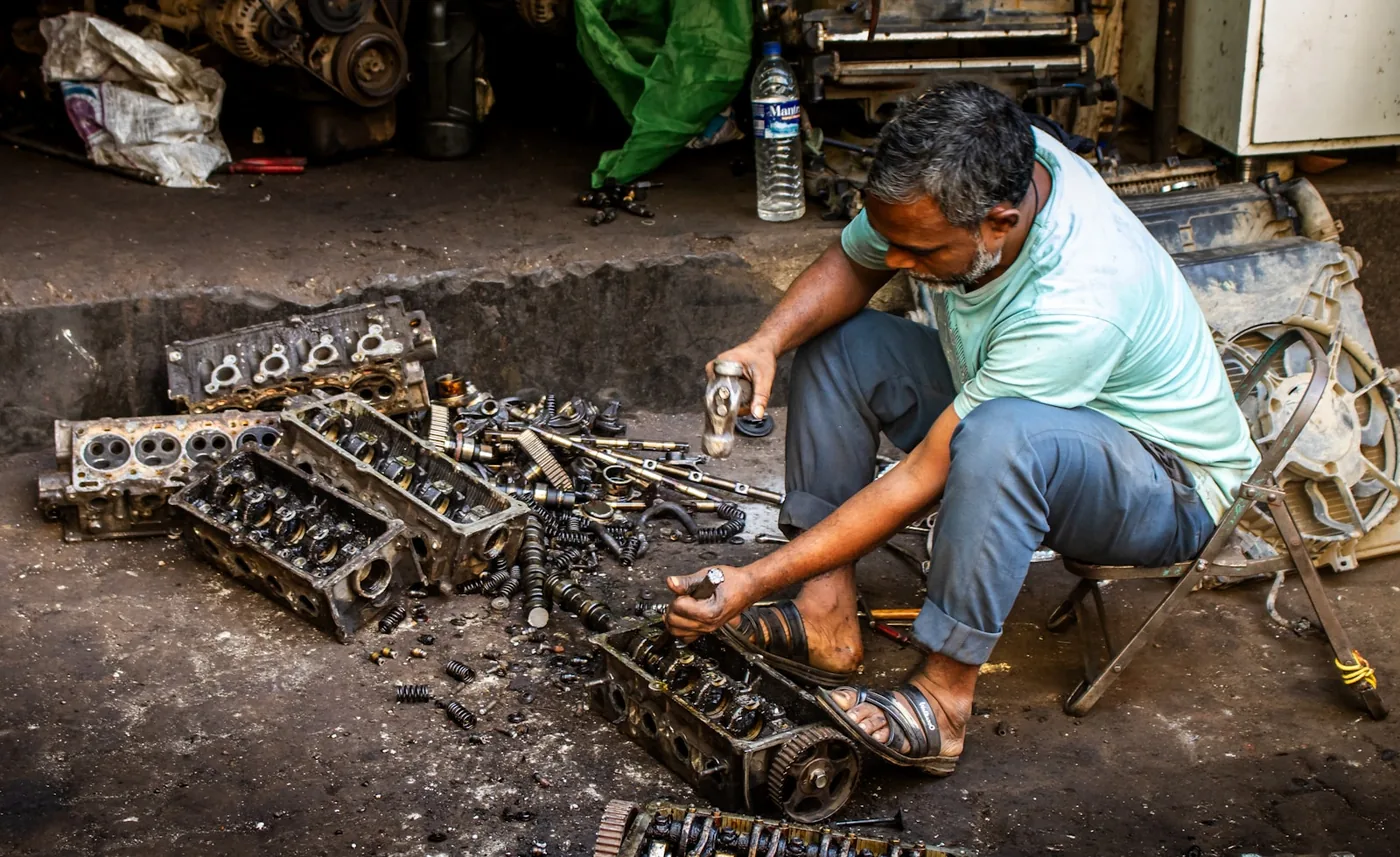 A mechanic working on engine parts in a workshop