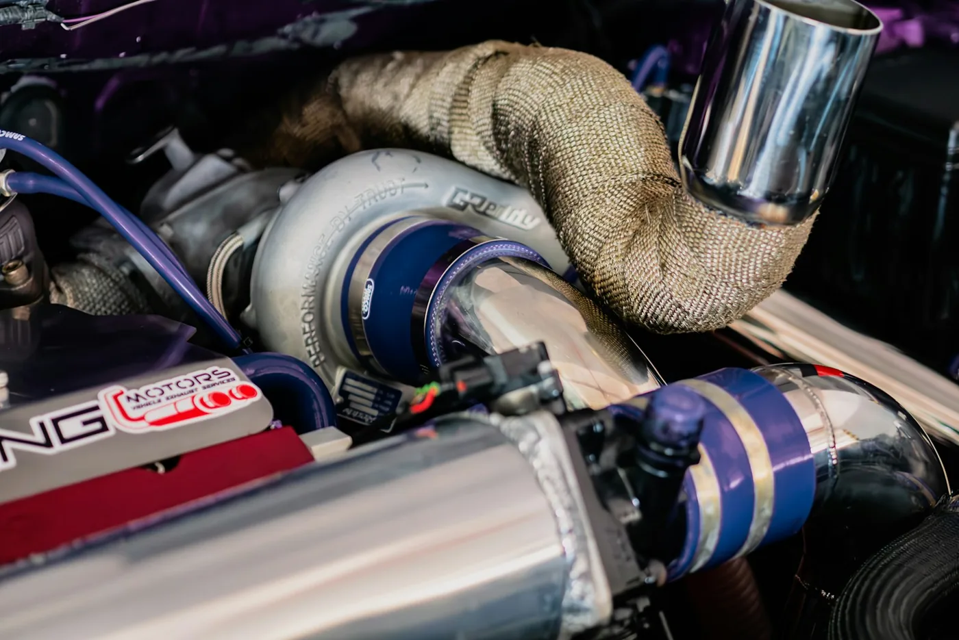 A heat-wrapped exhaust pipe in an engine bay