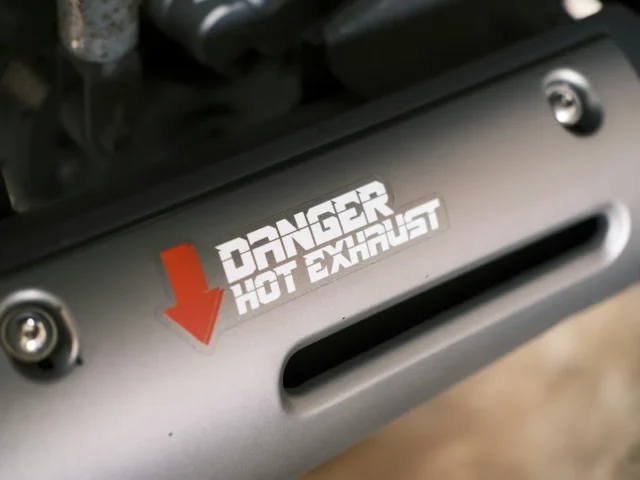 A silencer carrying a hot-exhaust warning decal