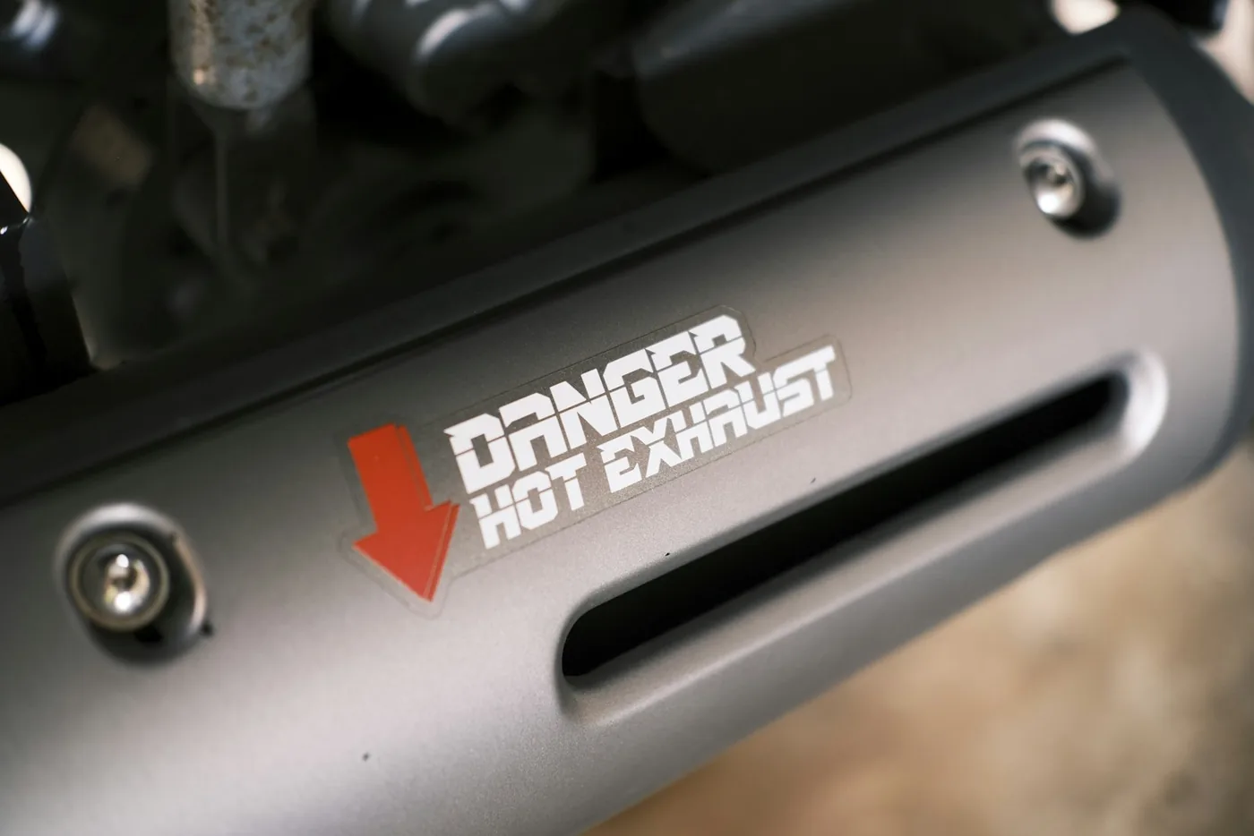 A silencer carrying a hot-exhaust warning decal