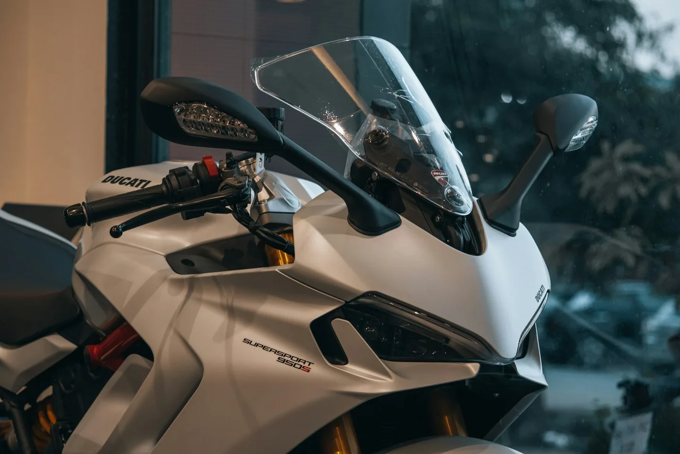 A white motorcycle beside a window