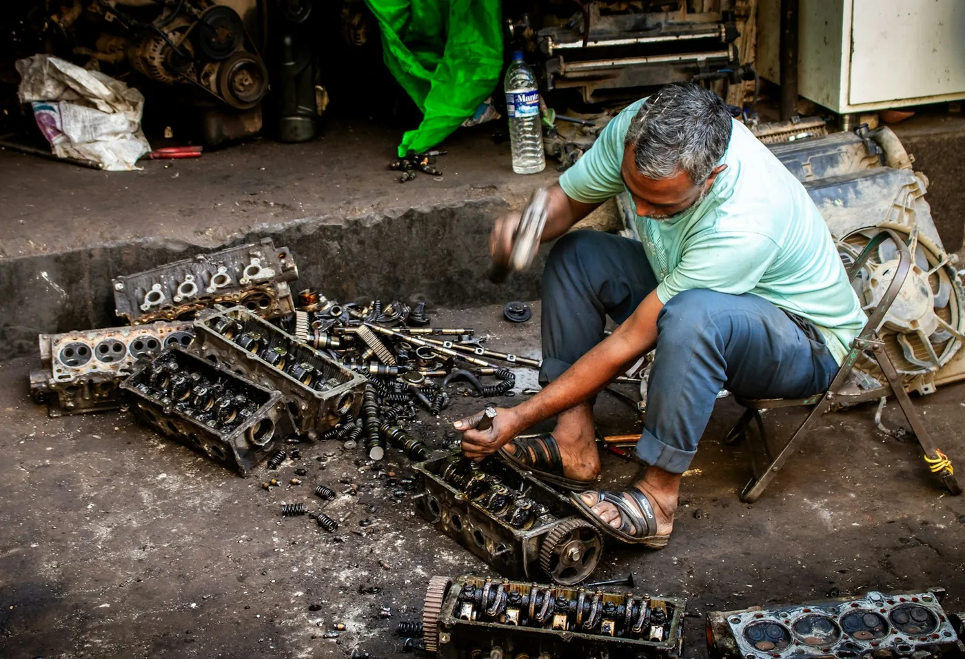 A mechanic working on cylinder heads in a workshop