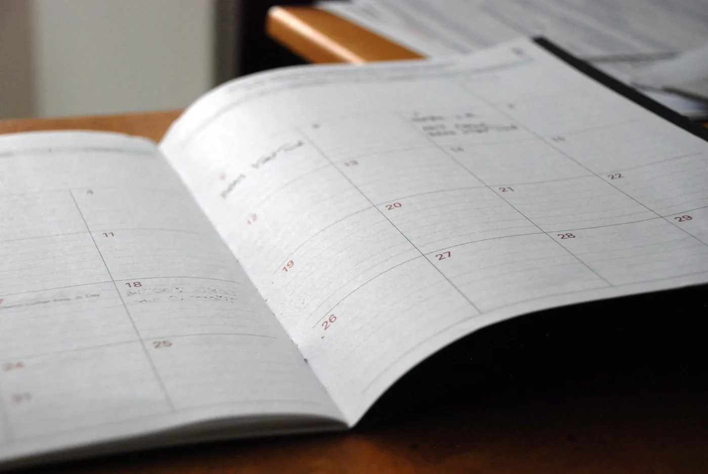open monthly planner on wooden desk
