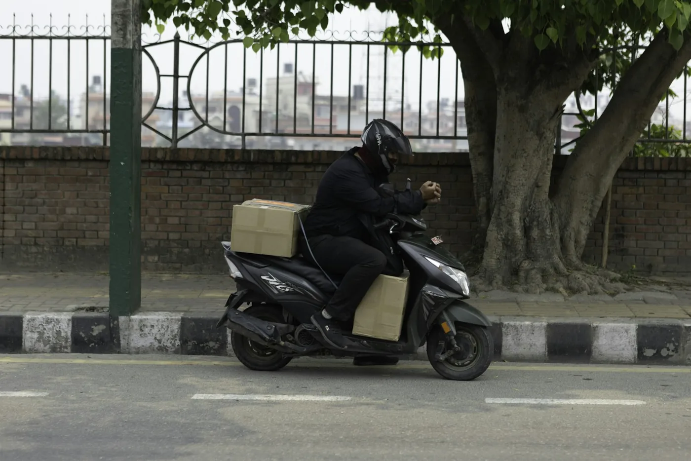 A rider carrying a parcel on a scooter
