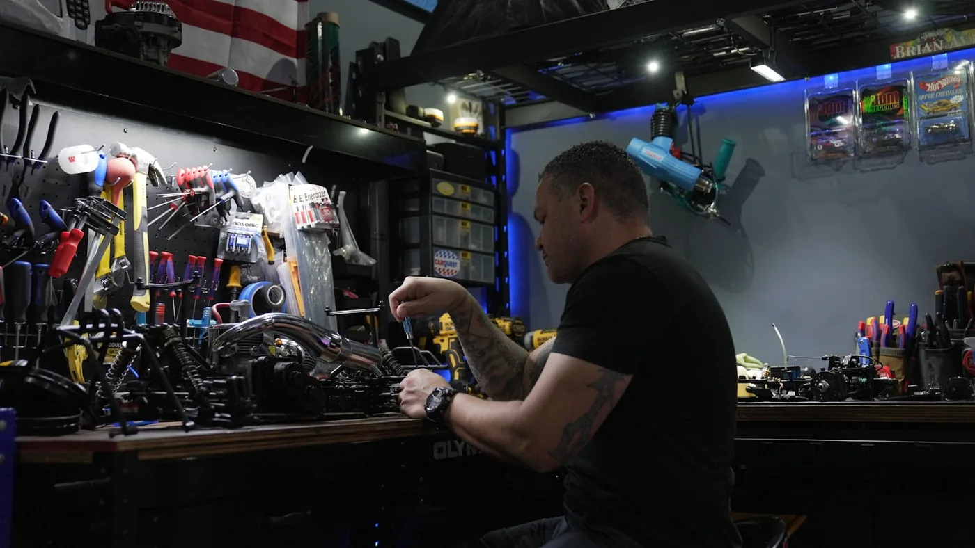 A mechanic at a workbench lined with tools