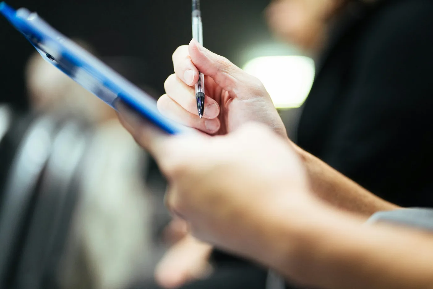 A hand writing on a clipboard