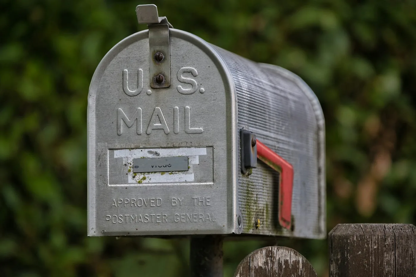 A weathered u.s. mailbox with a red flag