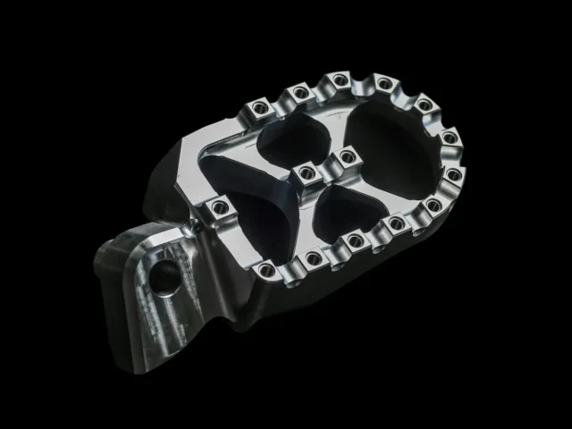 A footpeg photographed against black