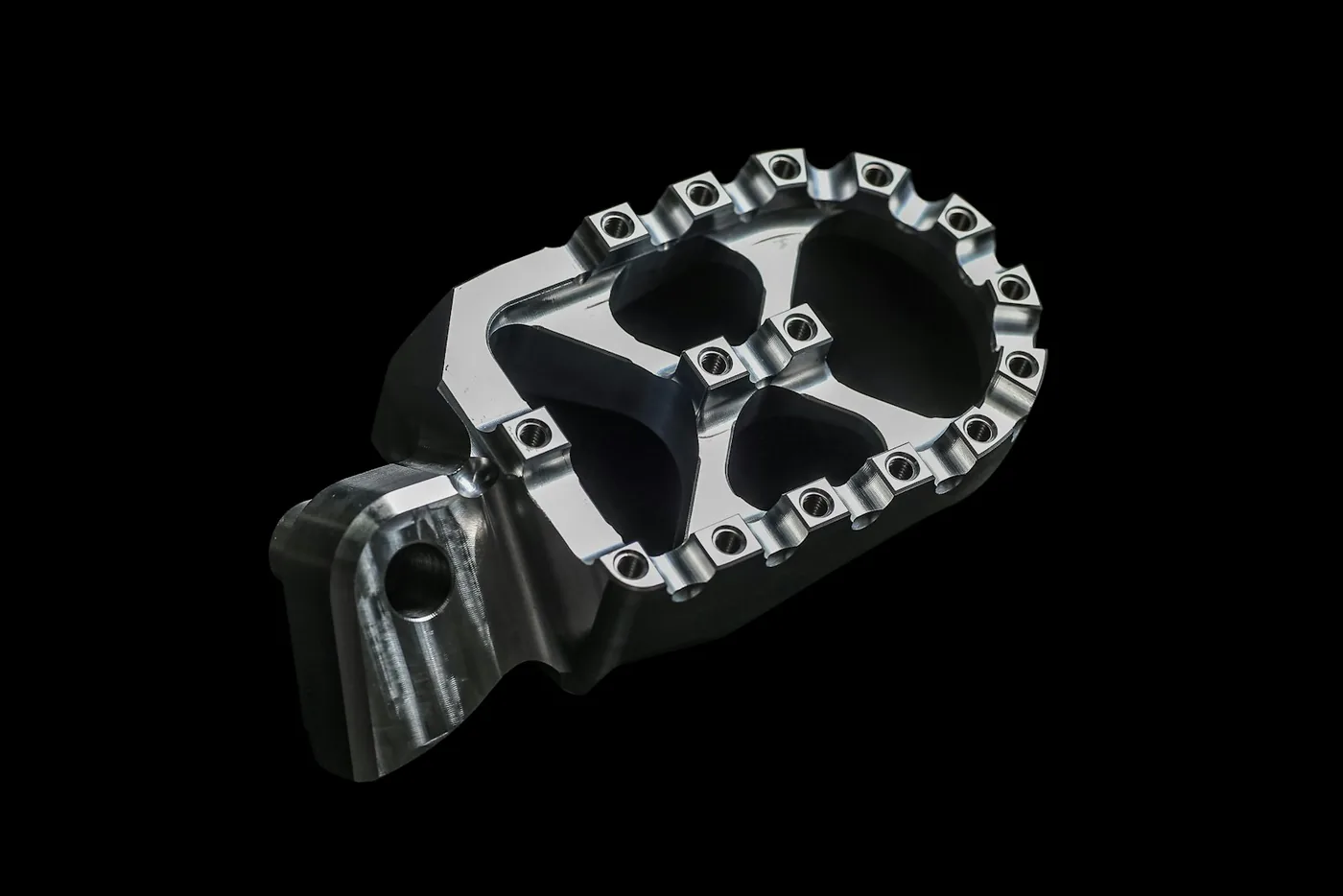 A footpeg photographed against black
