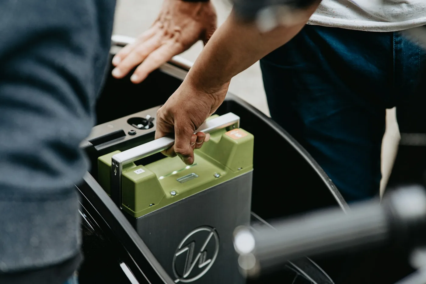 A battery box being lifted out by hand