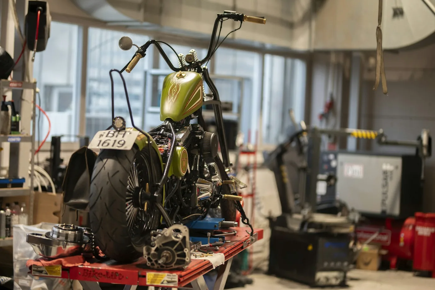 A stripped motorcycle on a workshop lift
