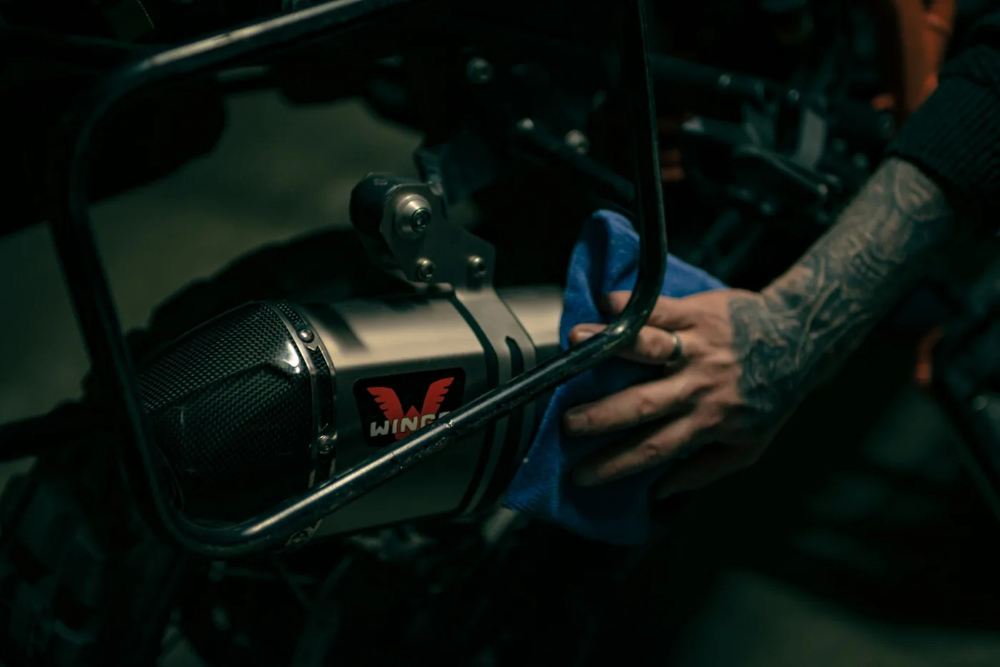 A hand wiping down a motorcycle
