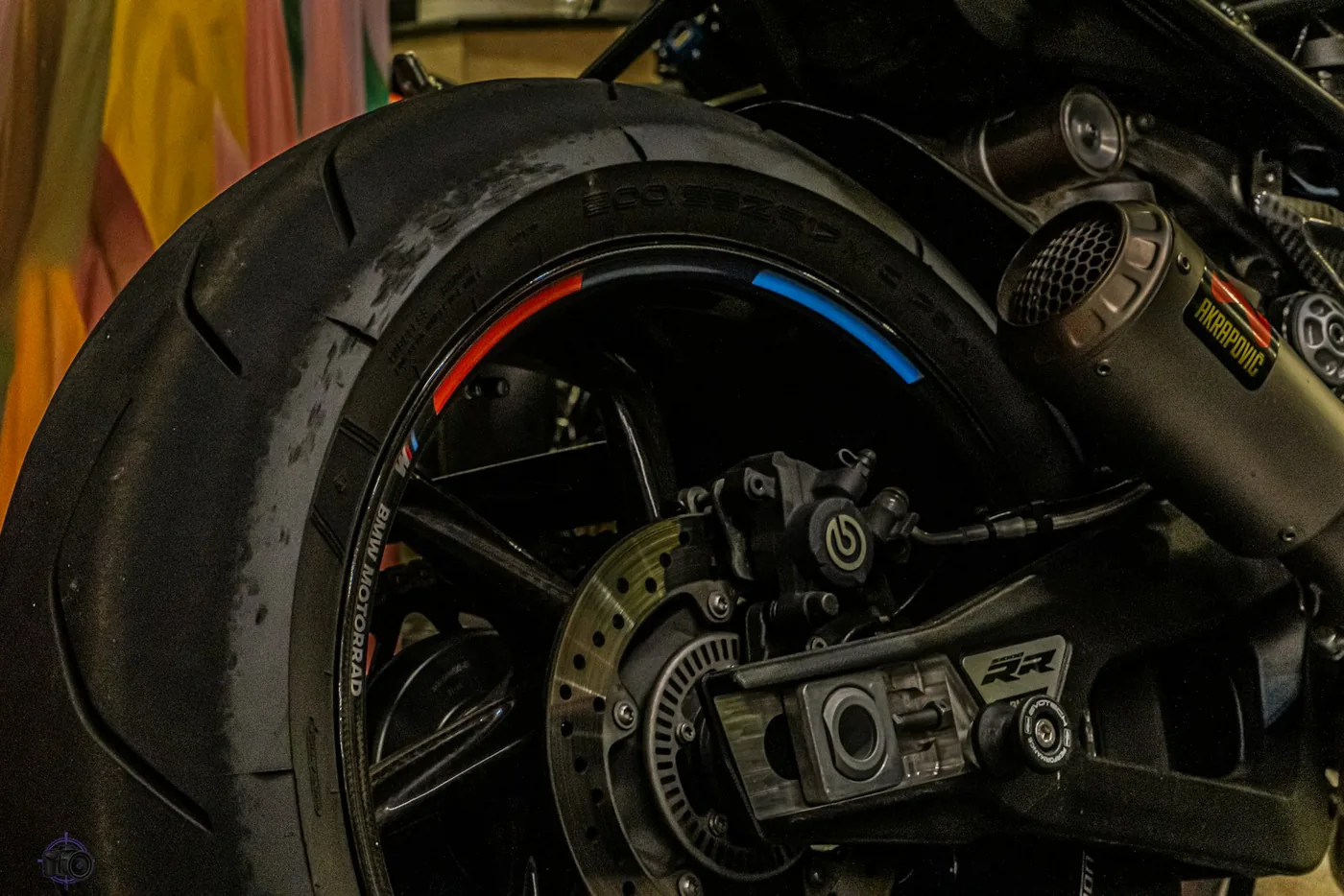 The rear wheel, brake disc and exhaust of a motorcycle