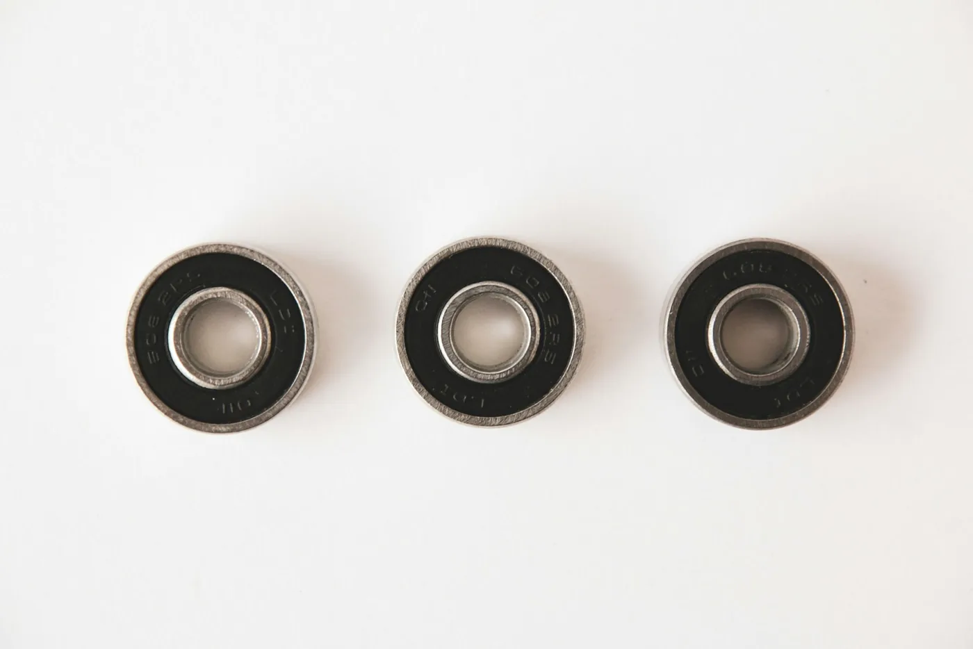 Three sealed bearings on a white background