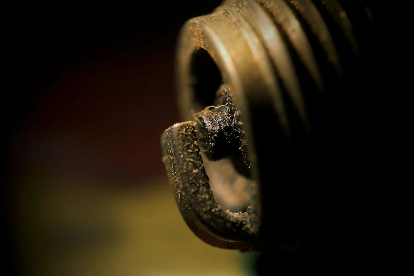 A threaded metal plug against a dark background