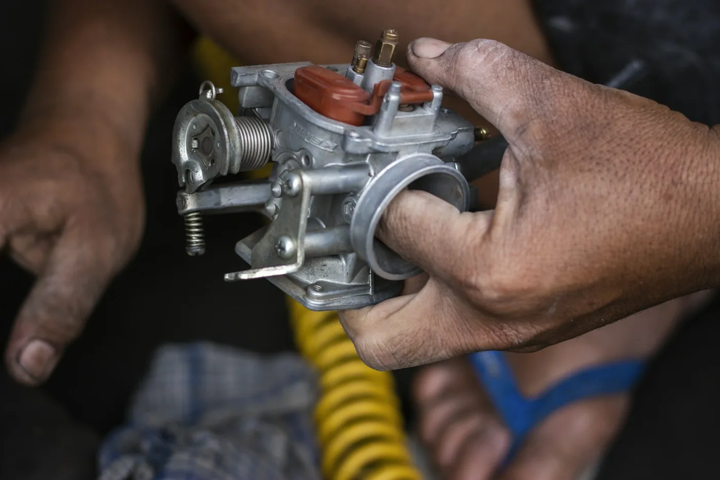 A mechanic holding a carburettor