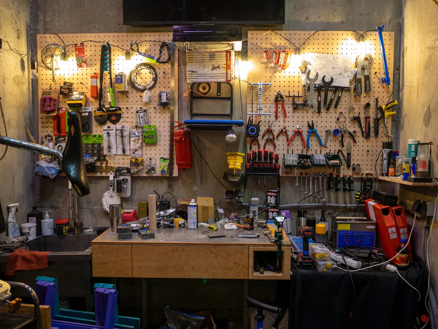 A workshop bench with tools racked above it