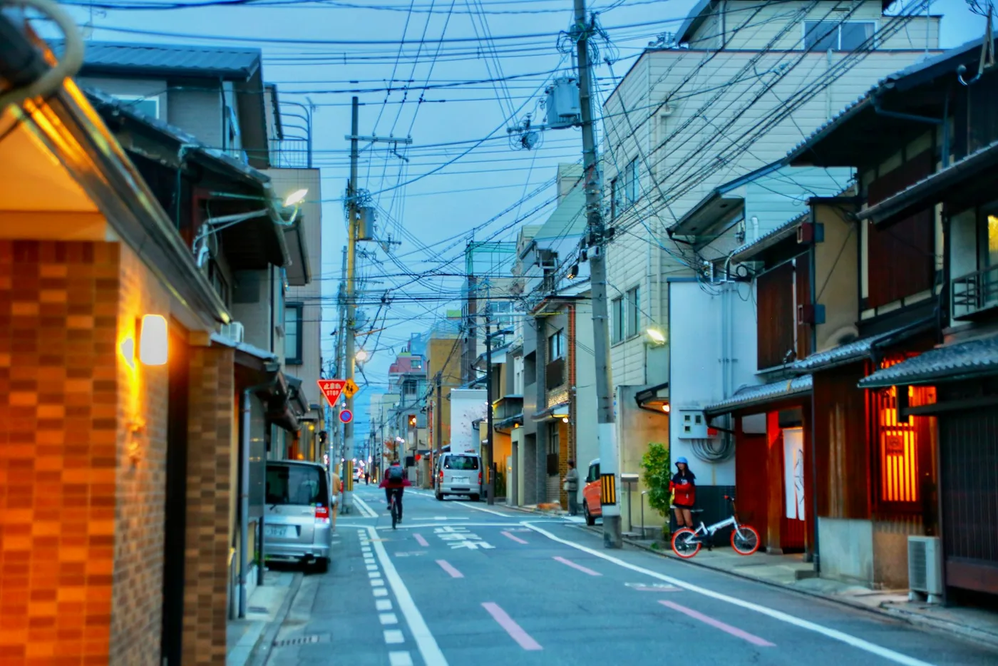a man riding a bike down a street next to tall buildings