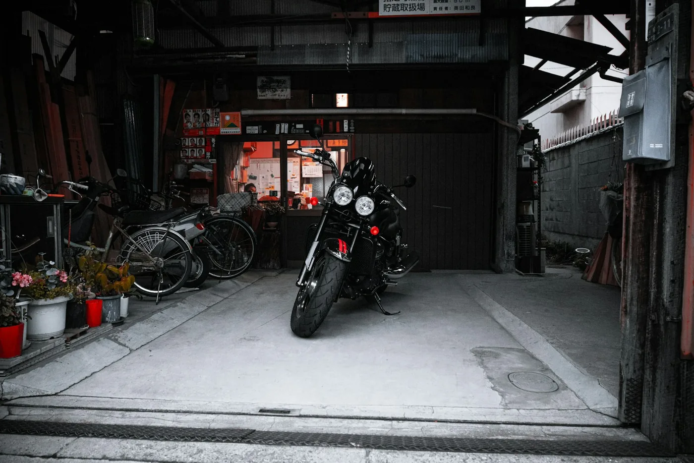a motorcycle parked inside of a garage next to bicycles