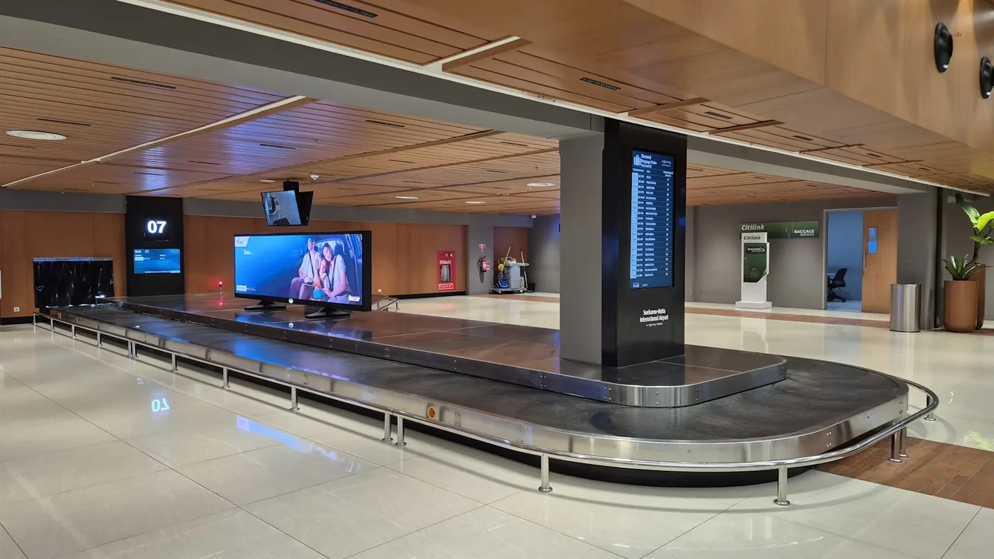 Modern airport baggage claim carousel with digital screens