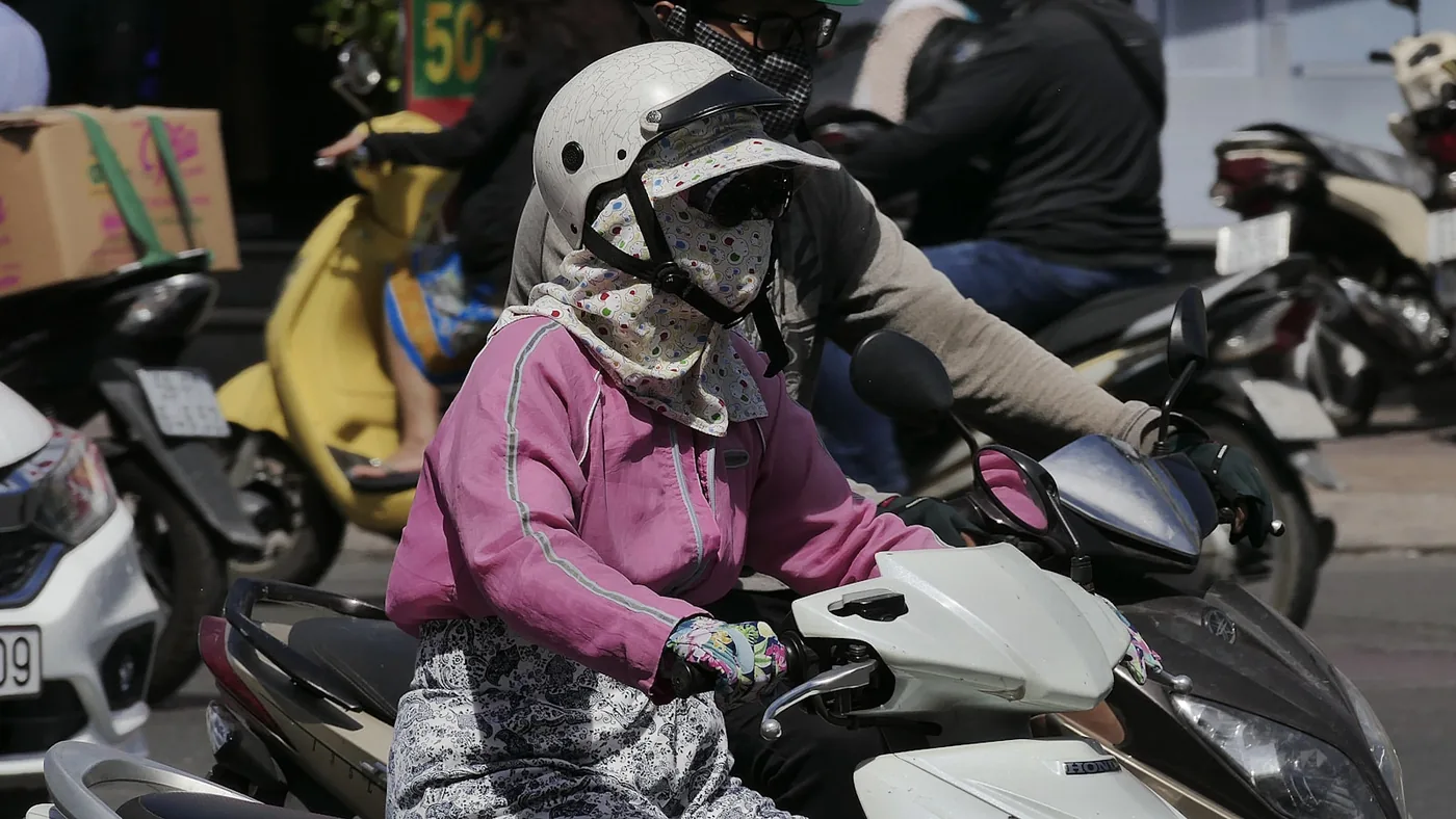 A rider on a scooter in city traffic