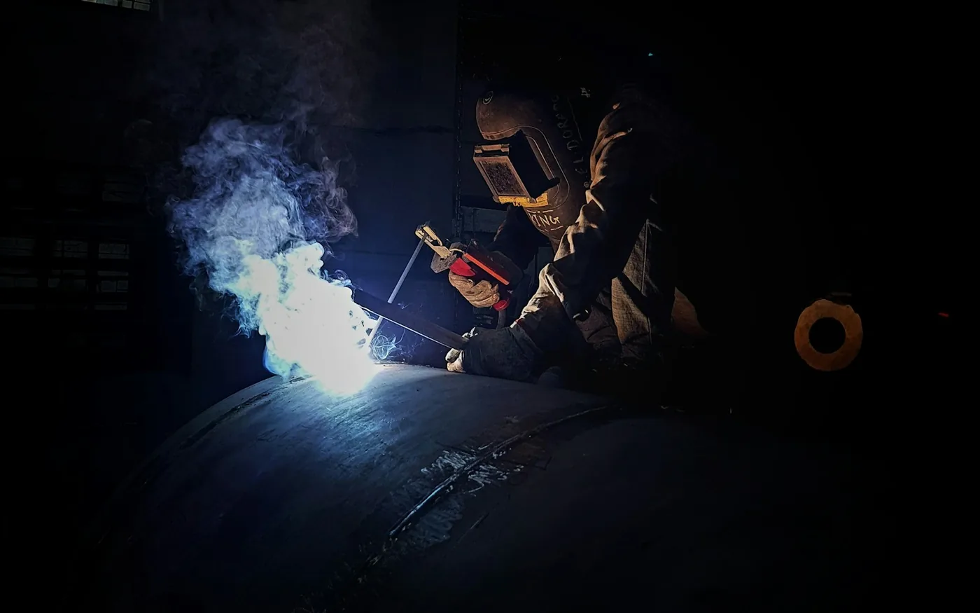 A welder working on a pipe